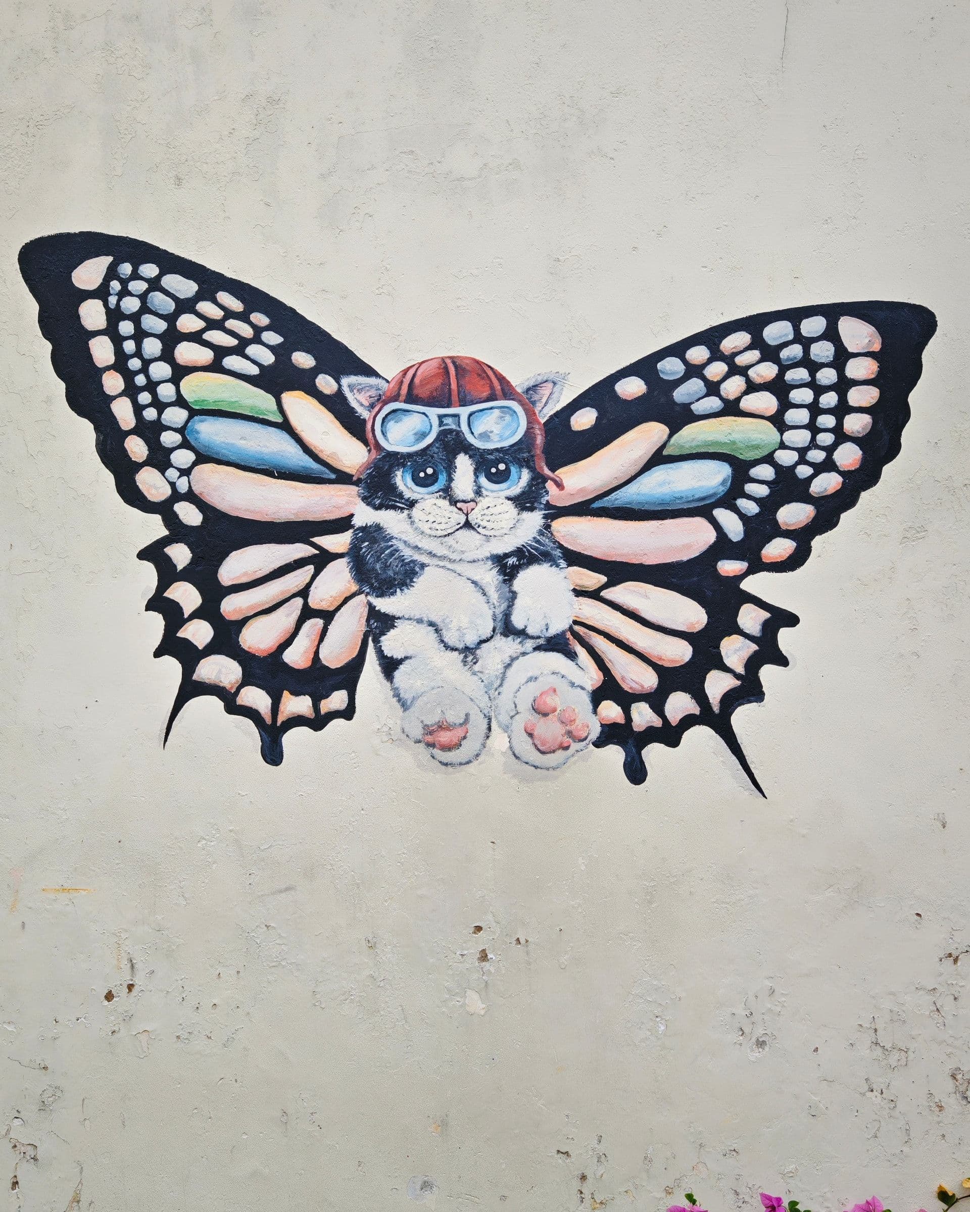 Butterfly Cat mural on Lebuh Acheh, a painted cat wearing aviator goggles and a butterfly-winged helmet